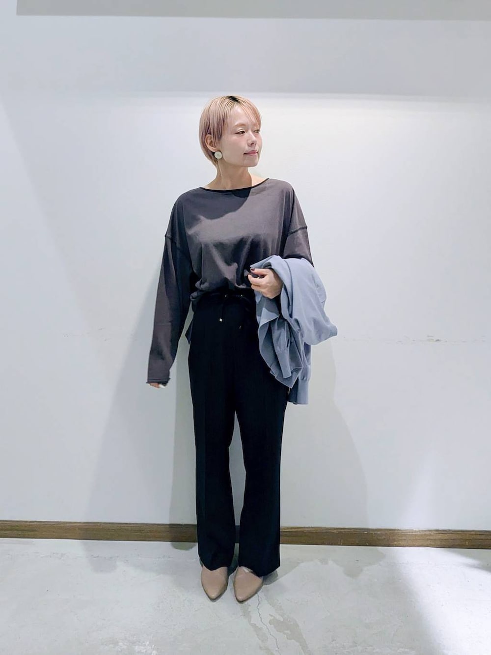 ベージュ系のパンプス、ブラウン系のボストンバッグ、ブルー系のカーディガン/ボレロを着用したレディースの秋コーディネートの5枚目の写真