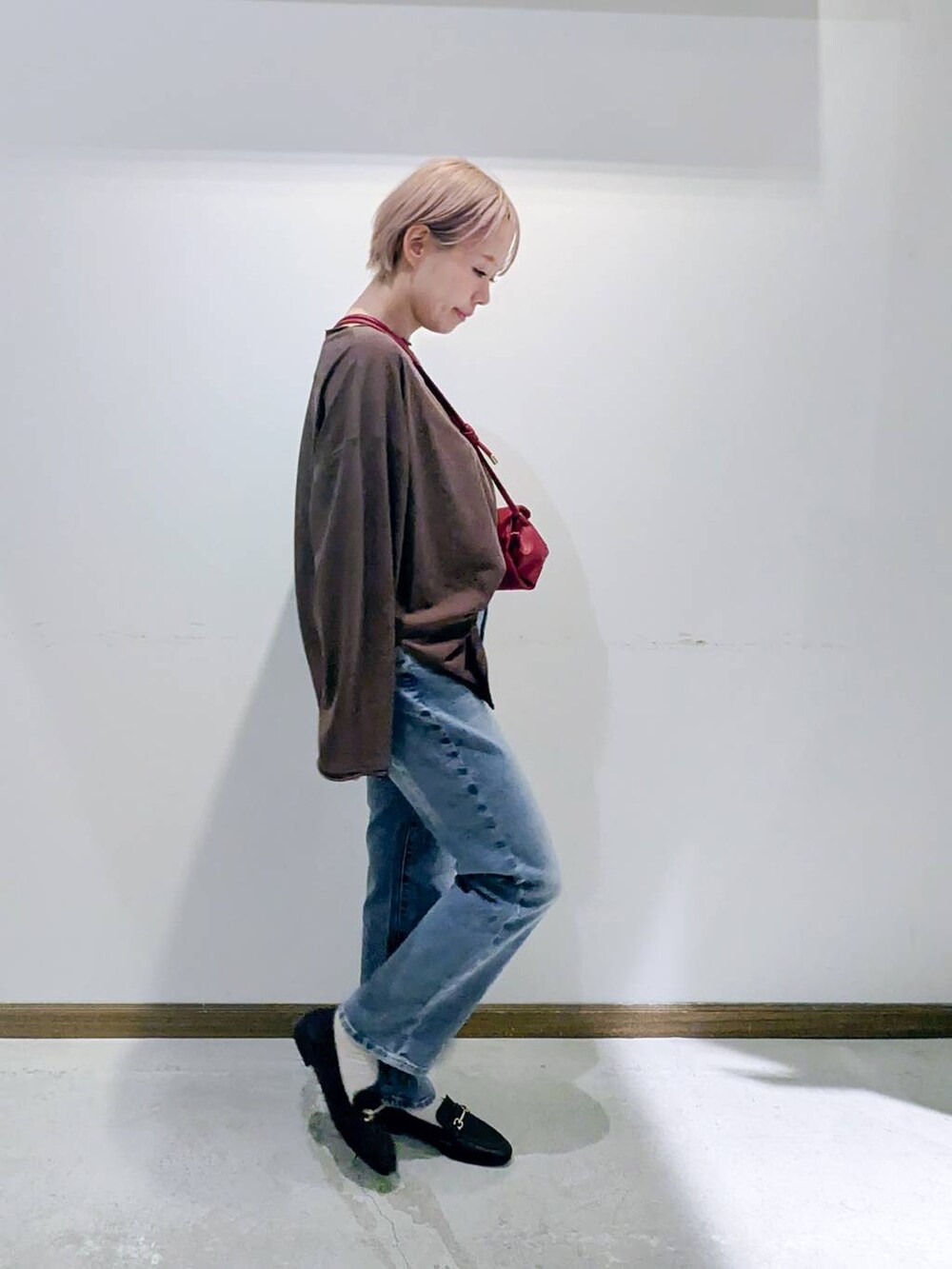 ブラウン系のローファー、ブラック系のキャミソール、ブルー系のデニムパンツを着用したレディースの秋コーディネートの2枚目の写真