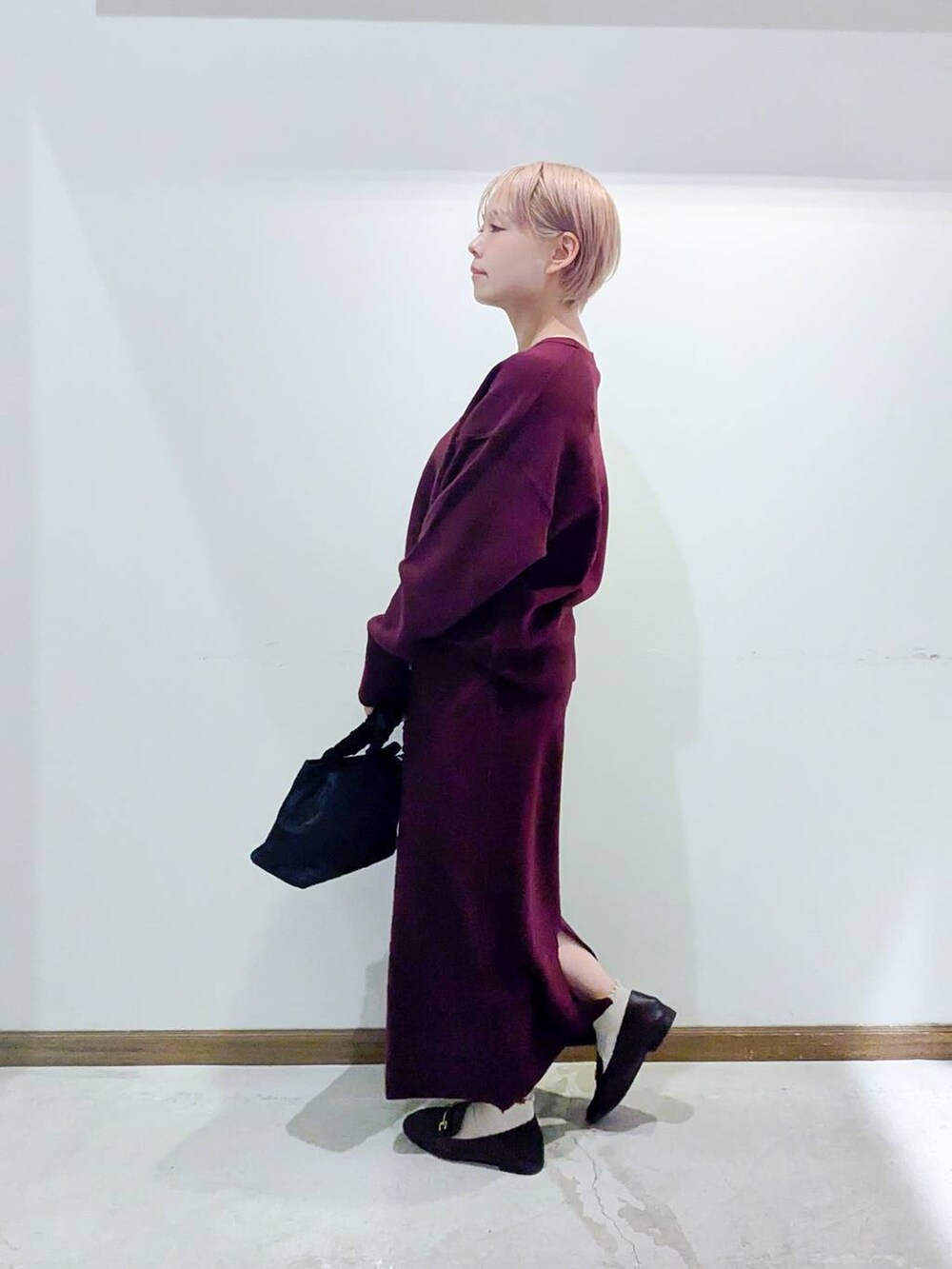 ブラウン系のローファー、ブラック系のショルダーバッグ、レッド系のニット/セーターを着用したレディースの秋コーディネートの4枚目の写真