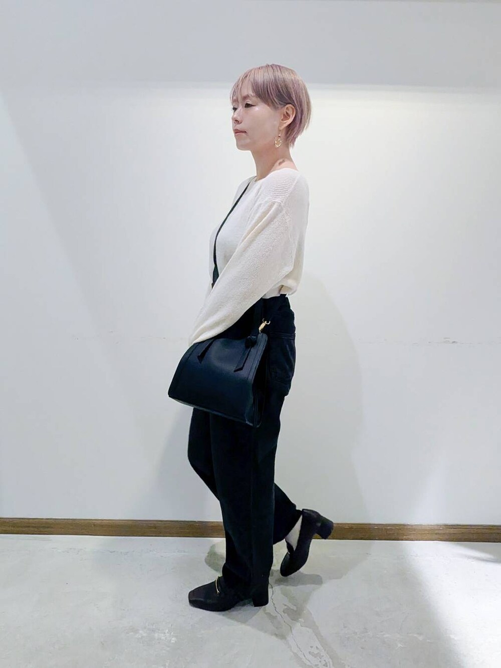 ブラック系のローファー、ブラック系のショルダーバッグ、ブルー系のデニムパンツを着用したレディースの秋コーディネートの4枚目の写真