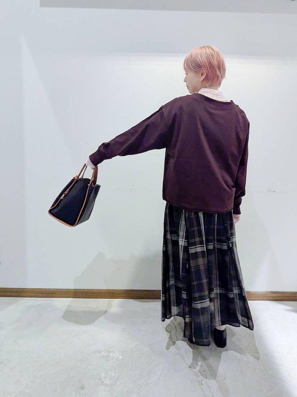 ブラック系のローファー、ブラック系のスカート、ブラック系のトートバッグを着用したレディースの秋コーディネートの3枚目の写真