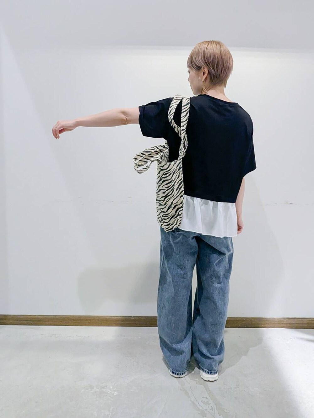 グレー系のスニーカー、その他のトートバッグ、ブルー系のデニムパンツを着用したレディースの夏コーディネートの3枚目の写真