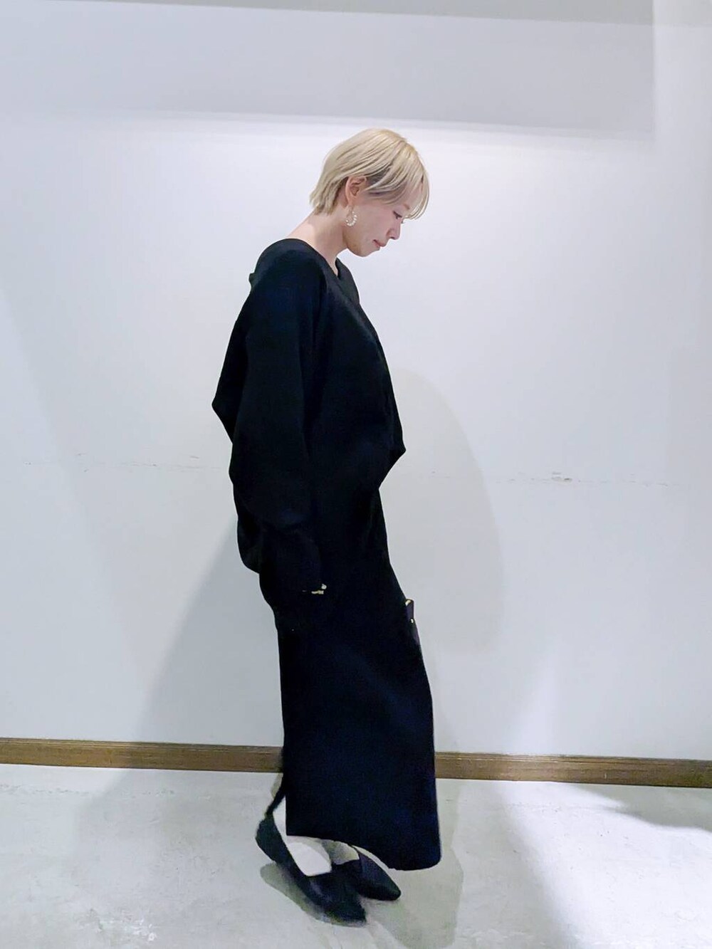 ブラック系のショルダーバッグ、ブラック系のパンプス、ブラック系のキャミソールを着用したレディースの冬コーディネートの2枚目の写真