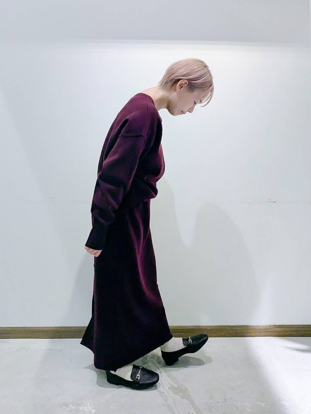 ブラウン系のローファー、ブラック系のショルダーバッグ、レッド系のニット/セーターを着用したレディースの秋コーディネートの2枚目の写真