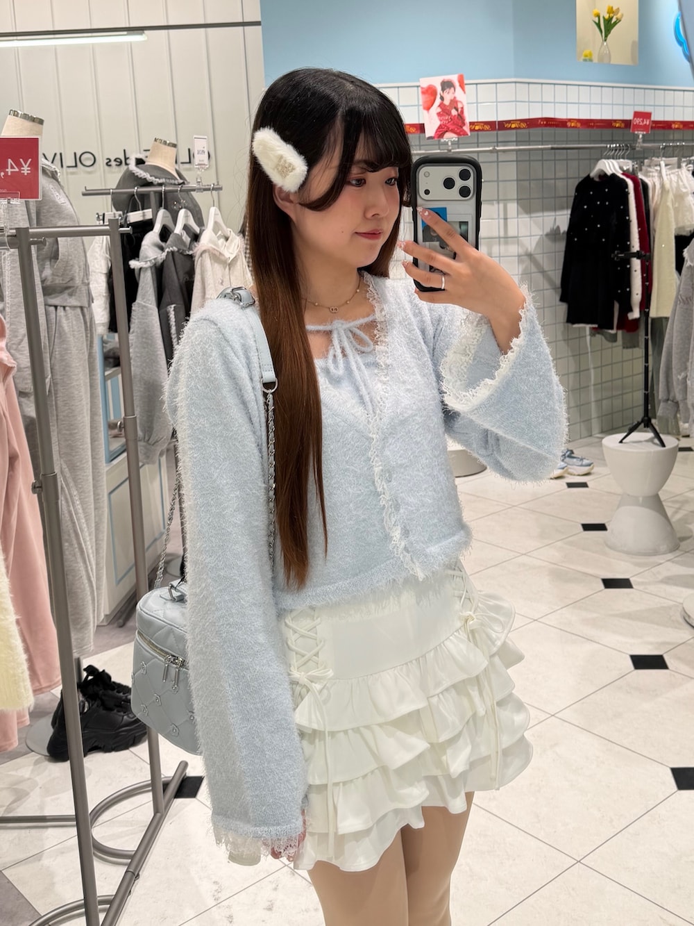 ブルー系のキャミソール、ブルー系のカーディガン/ボレロ、ホワイト系のスカートを着用したレディースの冬コーディネートの2枚目の写真