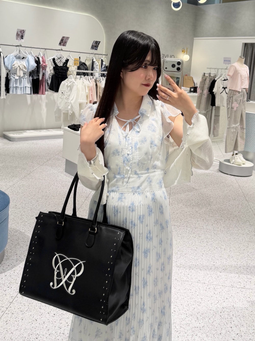 ブルー系のワンピース、ホワイト系のカーディガン/ボレロ、ブラック系のサンダルを着用したレディースの夏コーディネートの2枚目の写真