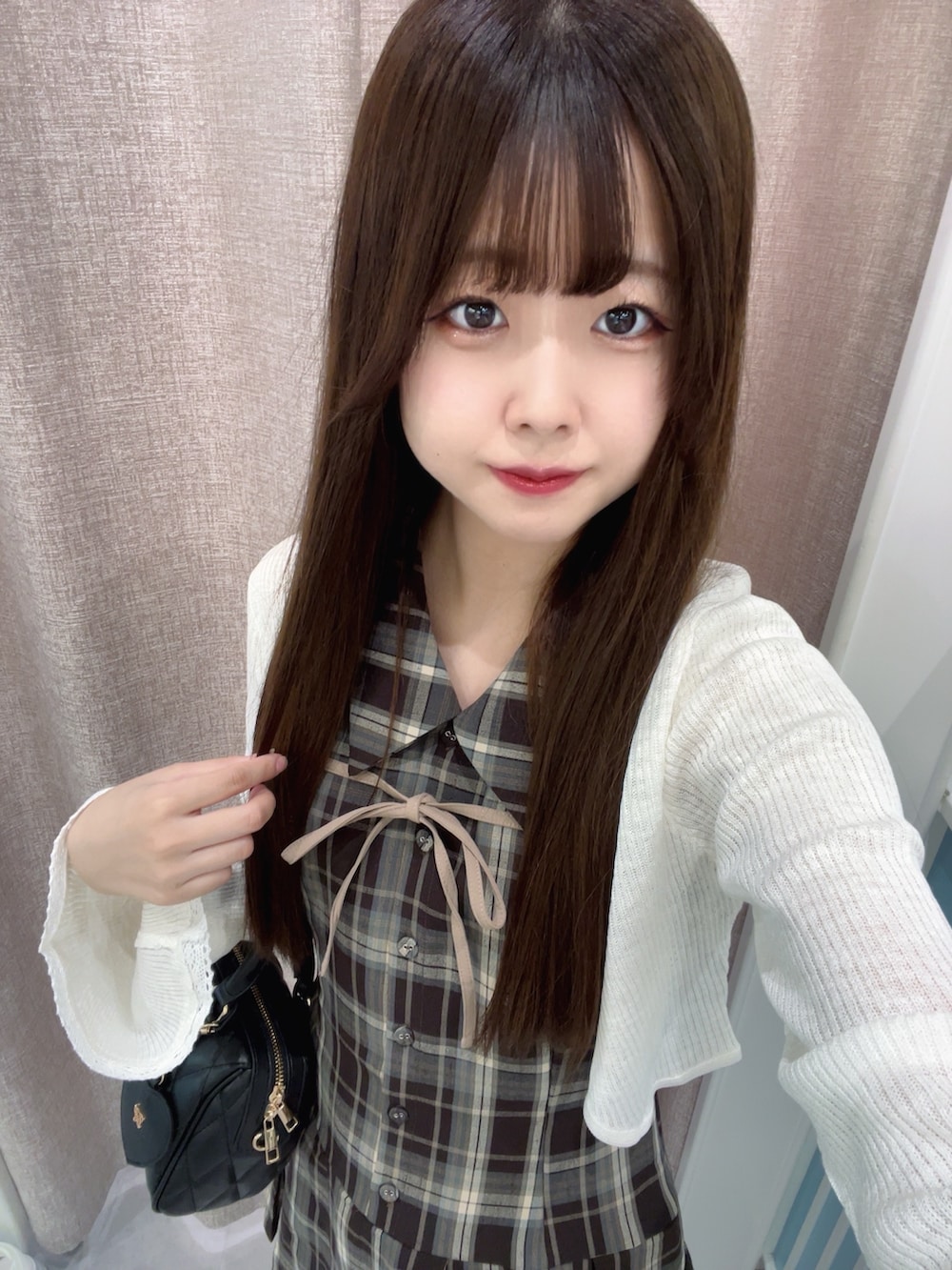 ブラウン系のワンピース、ホワイト系のカーディガン/ボレロ、ブラック系のボストンバッグを着用したレディースの夏コーディネートの3枚目の写真