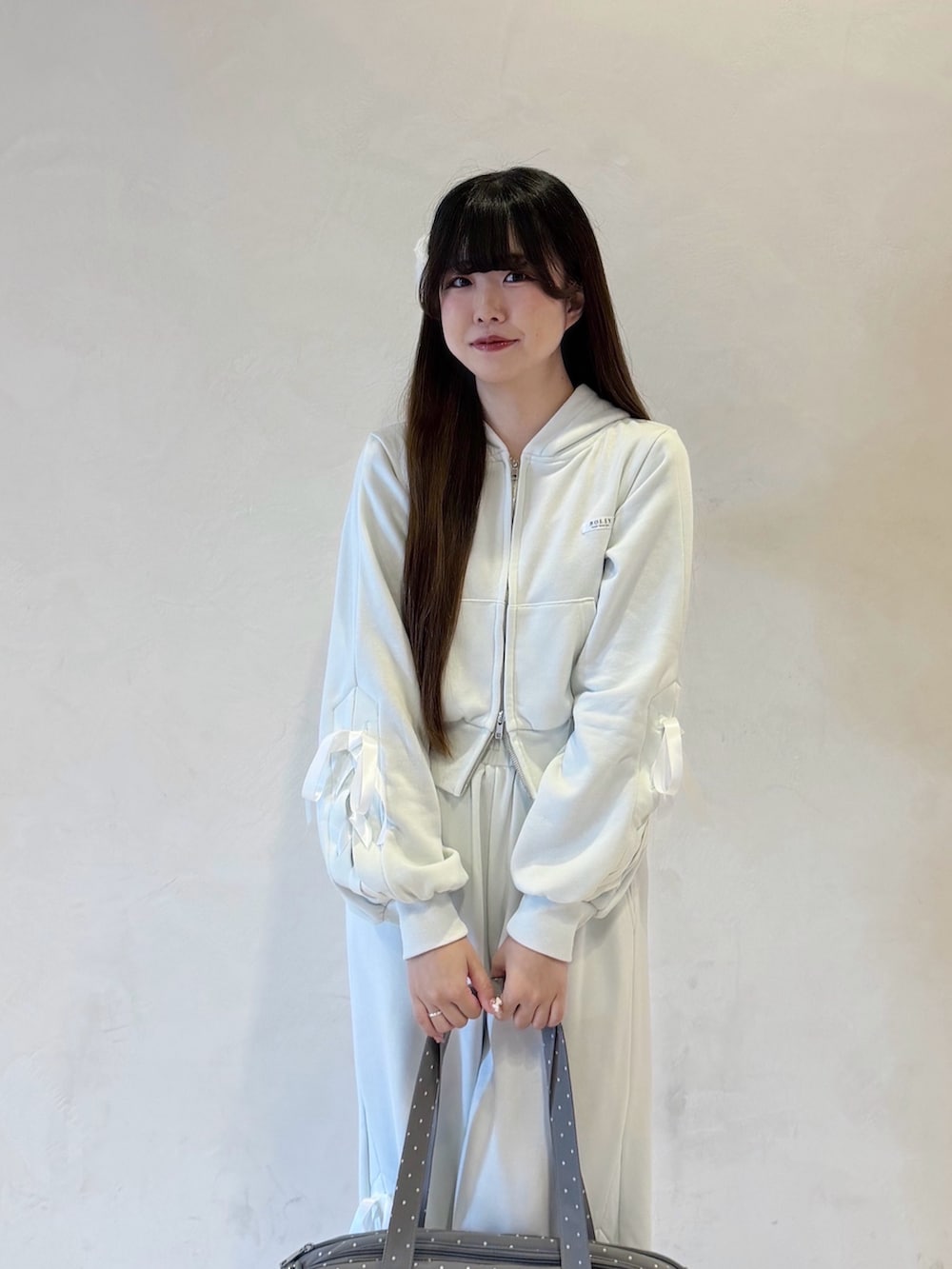 グリーン系のパーカー、グリーン系のスウェットパンツ、グレー系のボストンバッグを着用したレディースの冬コーディネートの2枚目の写真