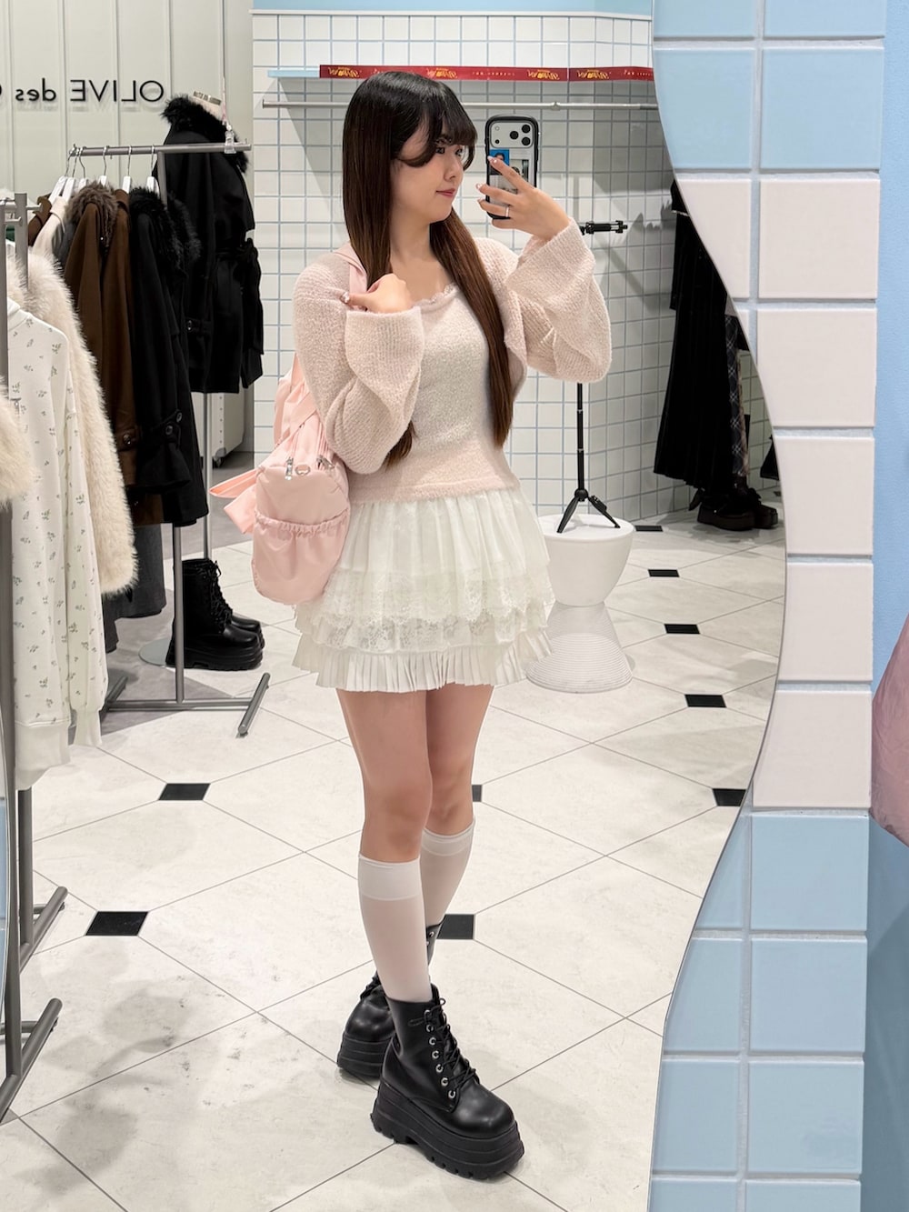 ピンク系のアンサンブル、ホワイト系のスカート、ピンク系のボストンバッグを着用したレディースの冬コーディネートの4枚目の写真