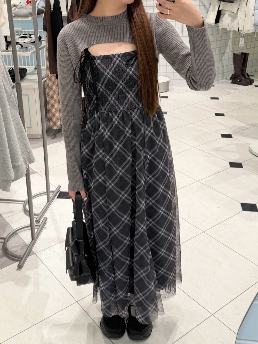 ブラック系のワンピース、ブラック系のショルダーバッグ、ブラック系のスニーカーを着用したレディースの冬コーディネートの3枚目の写真