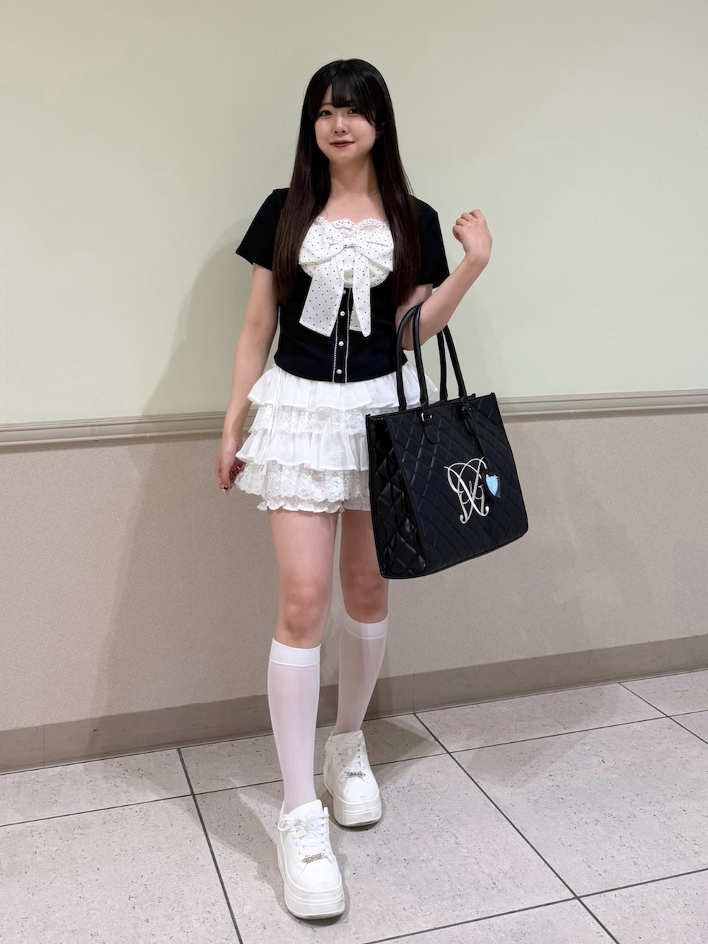 ブラック系のTシャツ/カットソー、ホワイト系のスカート、ブラック系のトートバッグを着用したレディースの夏コーディネートの4枚目の写真
