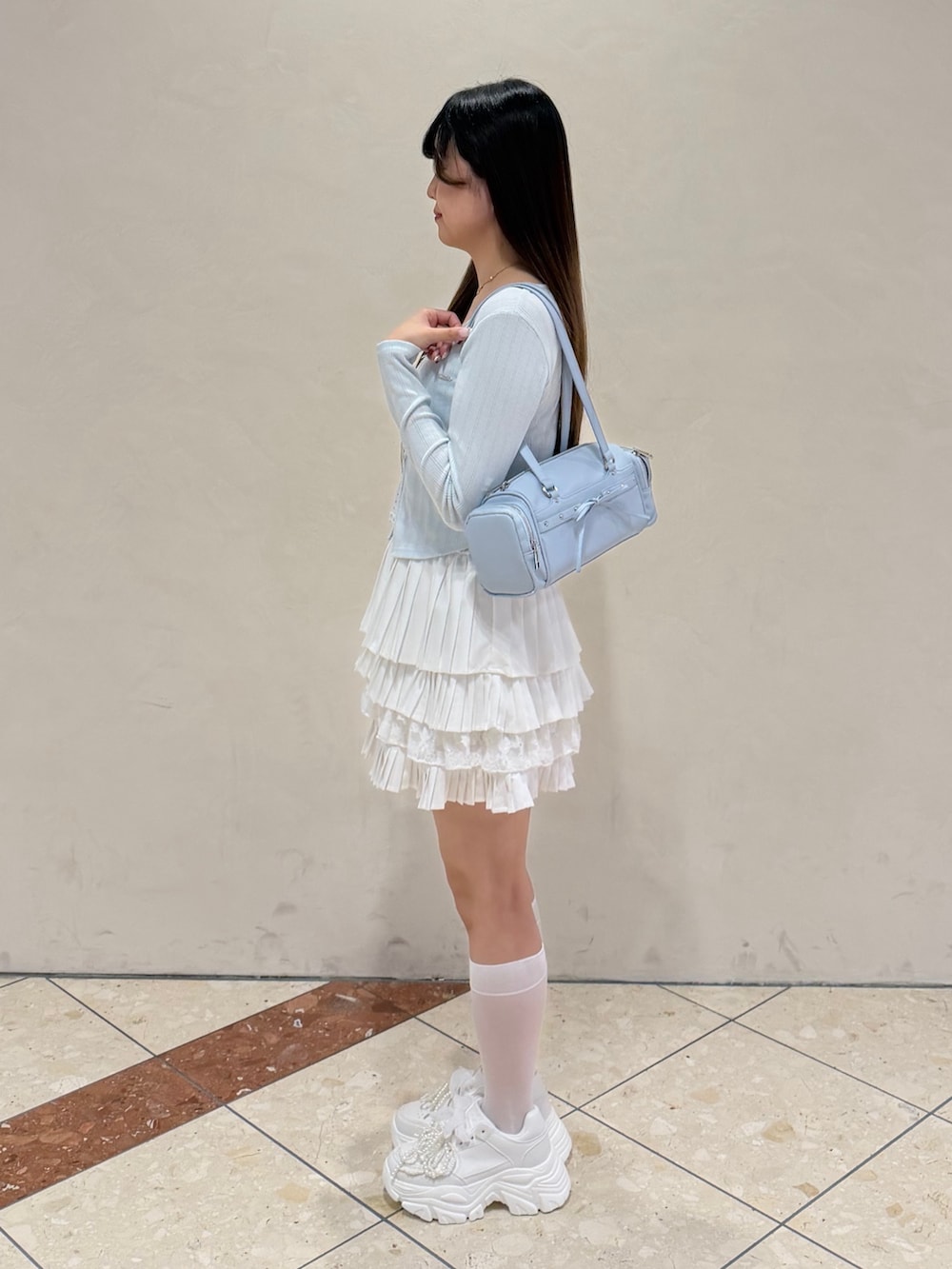 ブルー系のTシャツ/カットソー、ホワイト系のスカート、ホワイト系のスニーカーを着用したレディースの冬コーディネートの3枚目の写真