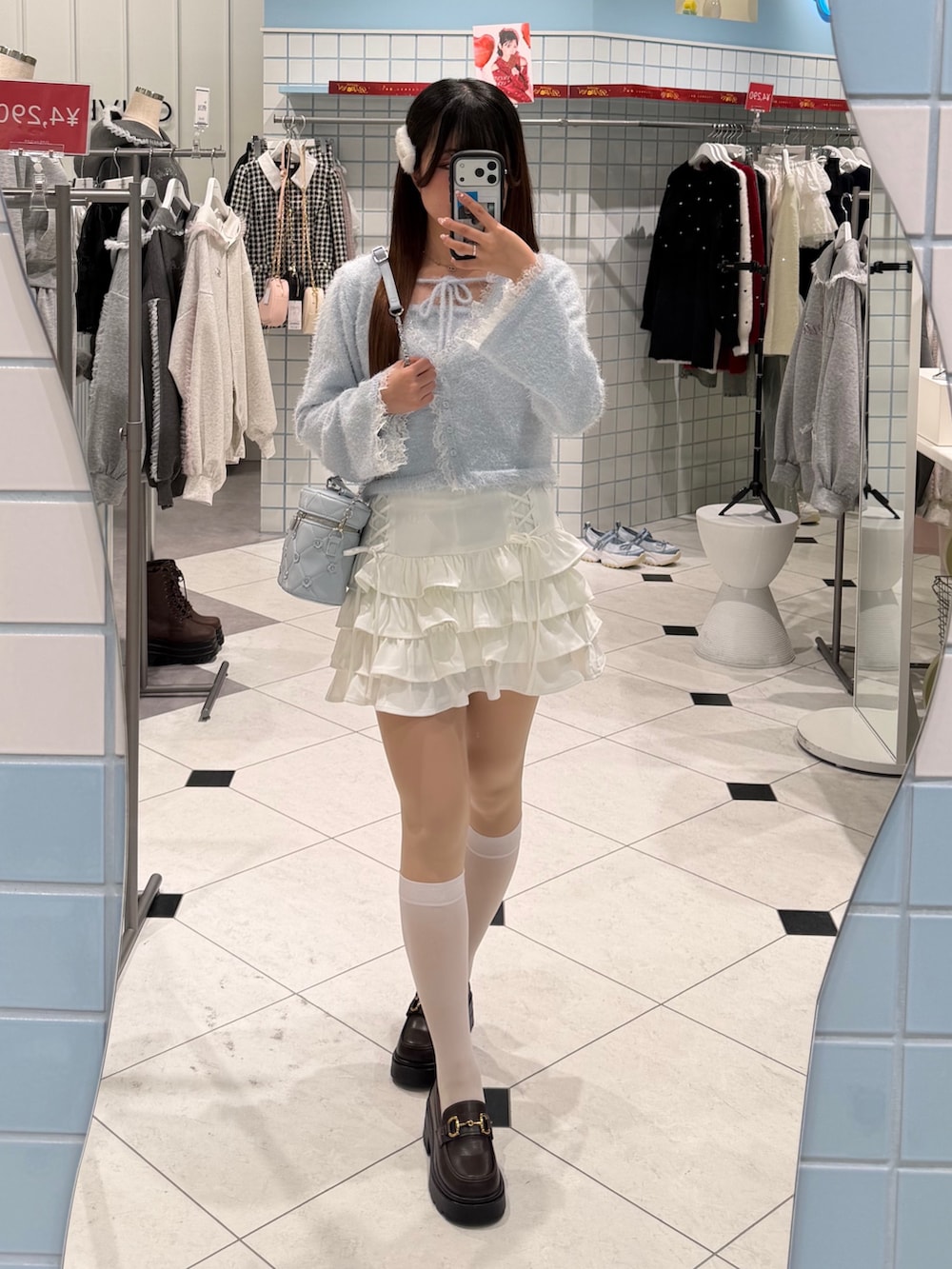 ブルー系のキャミソール、ブルー系のカーディガン/ボレロ、ホワイト系のスカートを着用したレディースの冬コーディネートの4枚目の写真