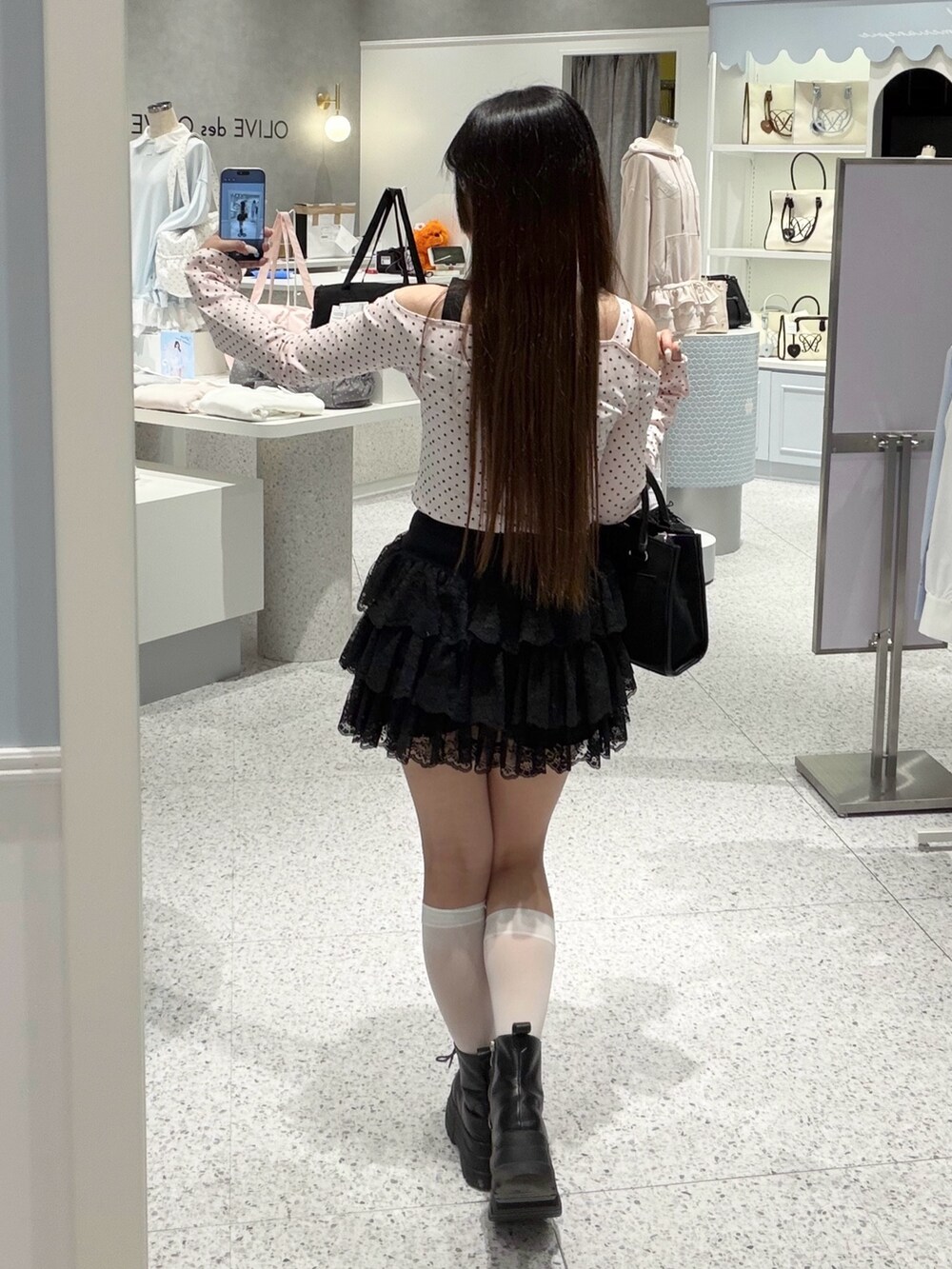 ピンク系のTシャツ/カットソー、ブラック系のスカート、ブラック系のトートバッグを着用したレディースの春コーディネートの4枚目の写真