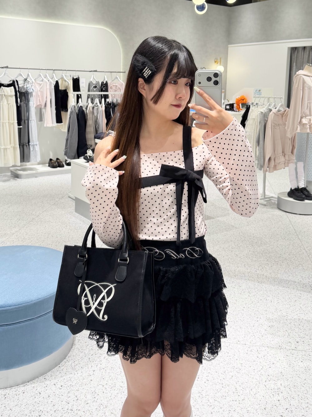 ピンク系のTシャツ/カットソー、ブラック系のスカート、ブラック系のトートバッグを着用したレディースの春コーディネートの3枚目の写真