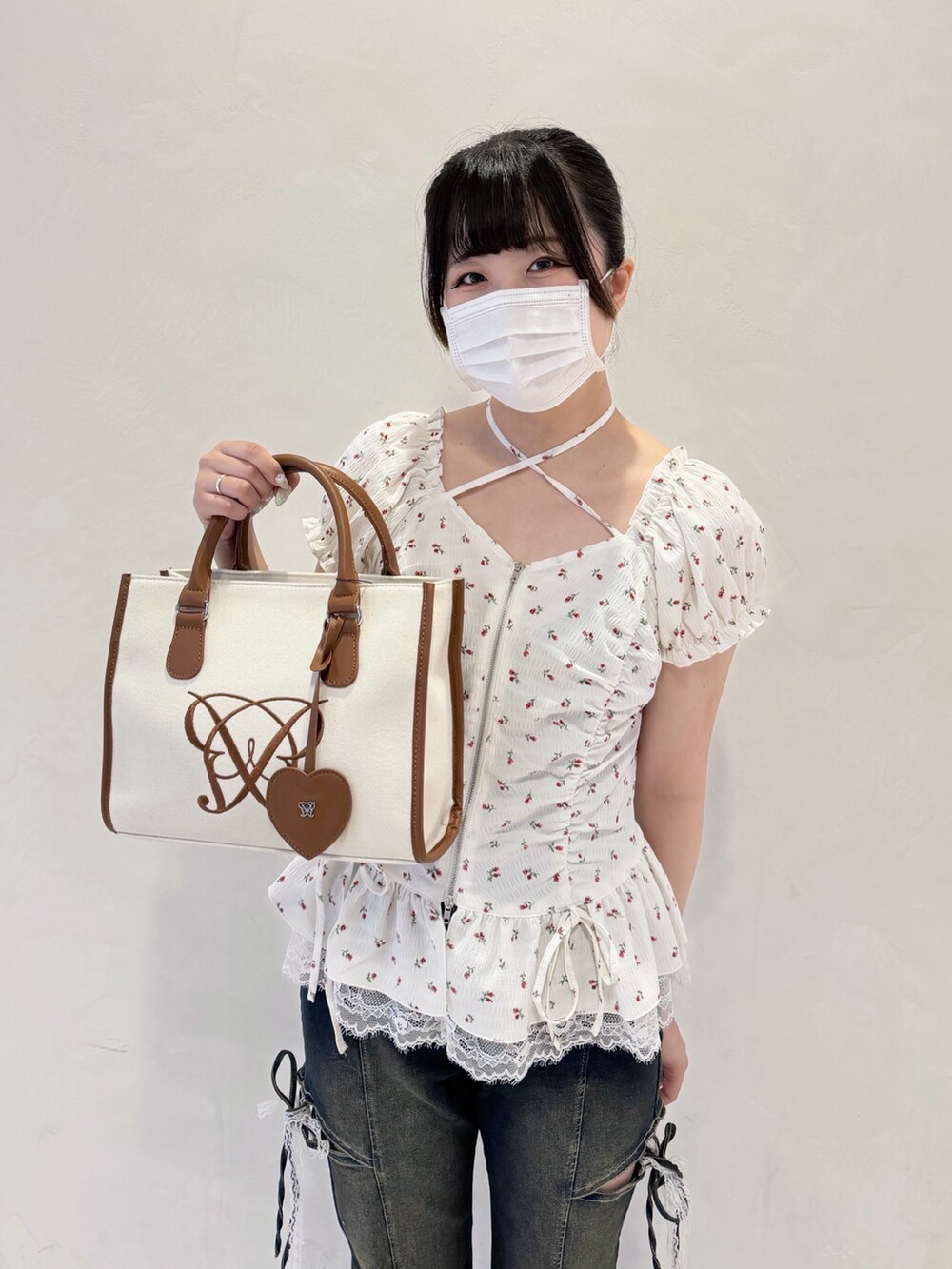 ホワイト系のシャツ/ブラウス、ブルー系のデニムパンツ、ブラウン系のトートバッグを着用したレディースの春コーディネートの4枚目の写真