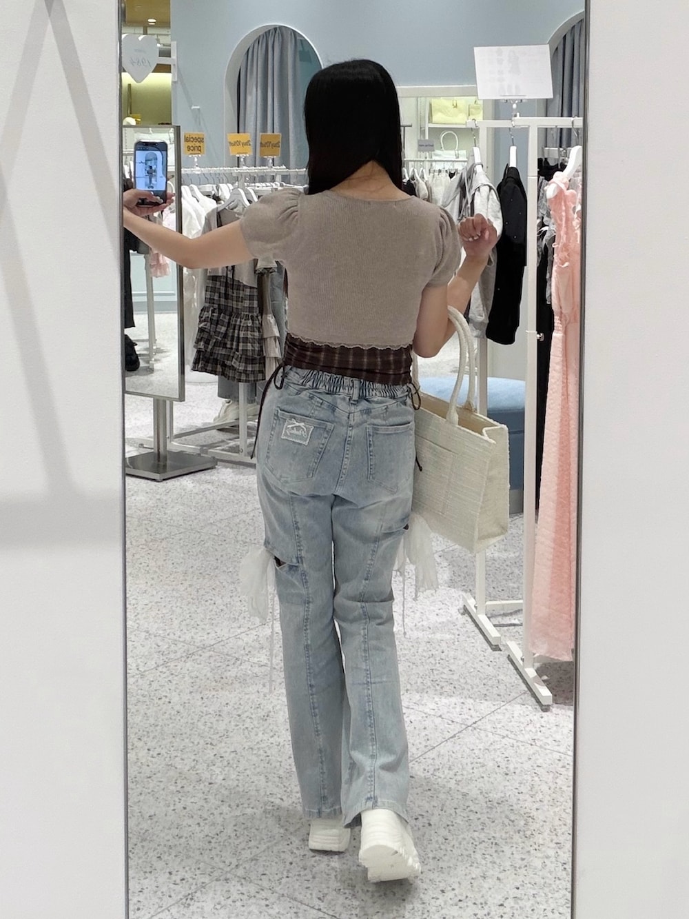 ベージュ系のワンピース、ブルー系のデニムパンツ、ホワイト系のトートバッグを着用したレディースの夏コーディネートの3枚目の写真