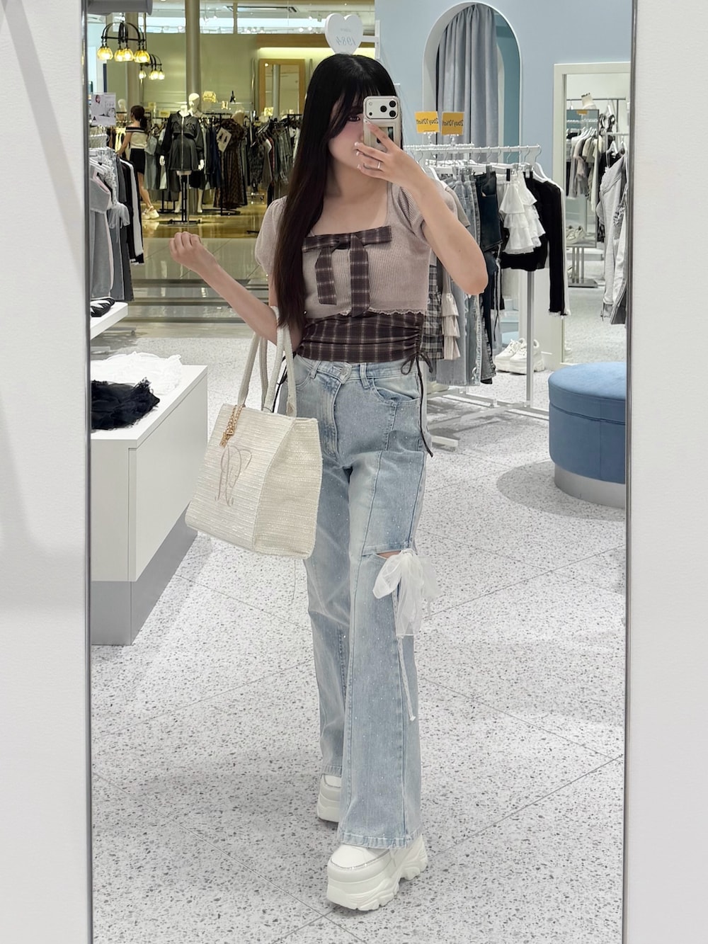 ベージュ系のワンピース、ブルー系のデニムパンツ、ホワイト系のトートバッグを着用したレディースの夏コーディネートの4枚目の写真