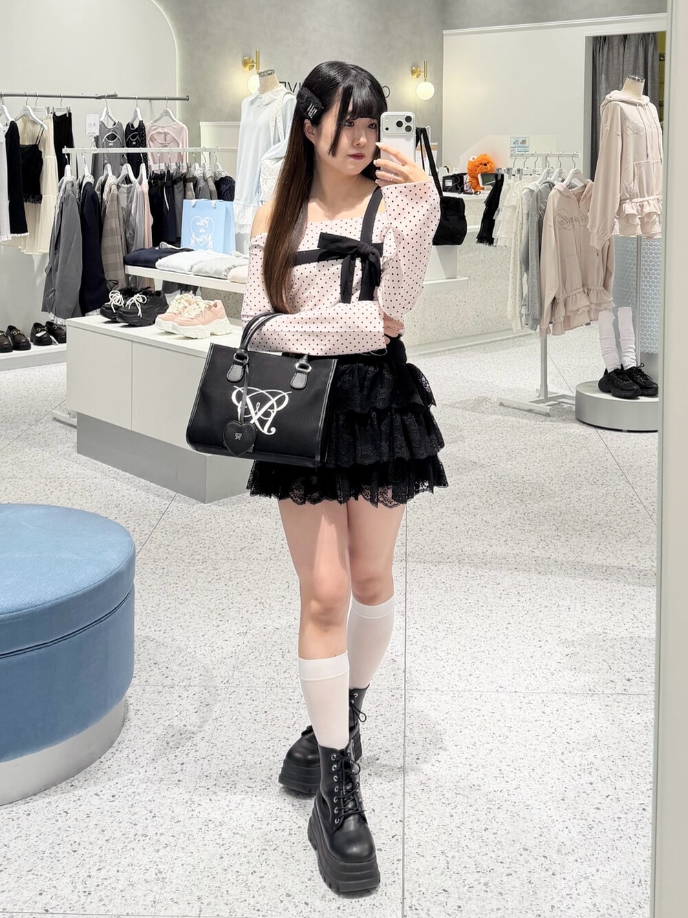 ピンク系のTシャツ/カットソー、ブラック系のスカート、ブラック系のトートバッグを着用したレディースの春コーディネートの5枚目の写真
