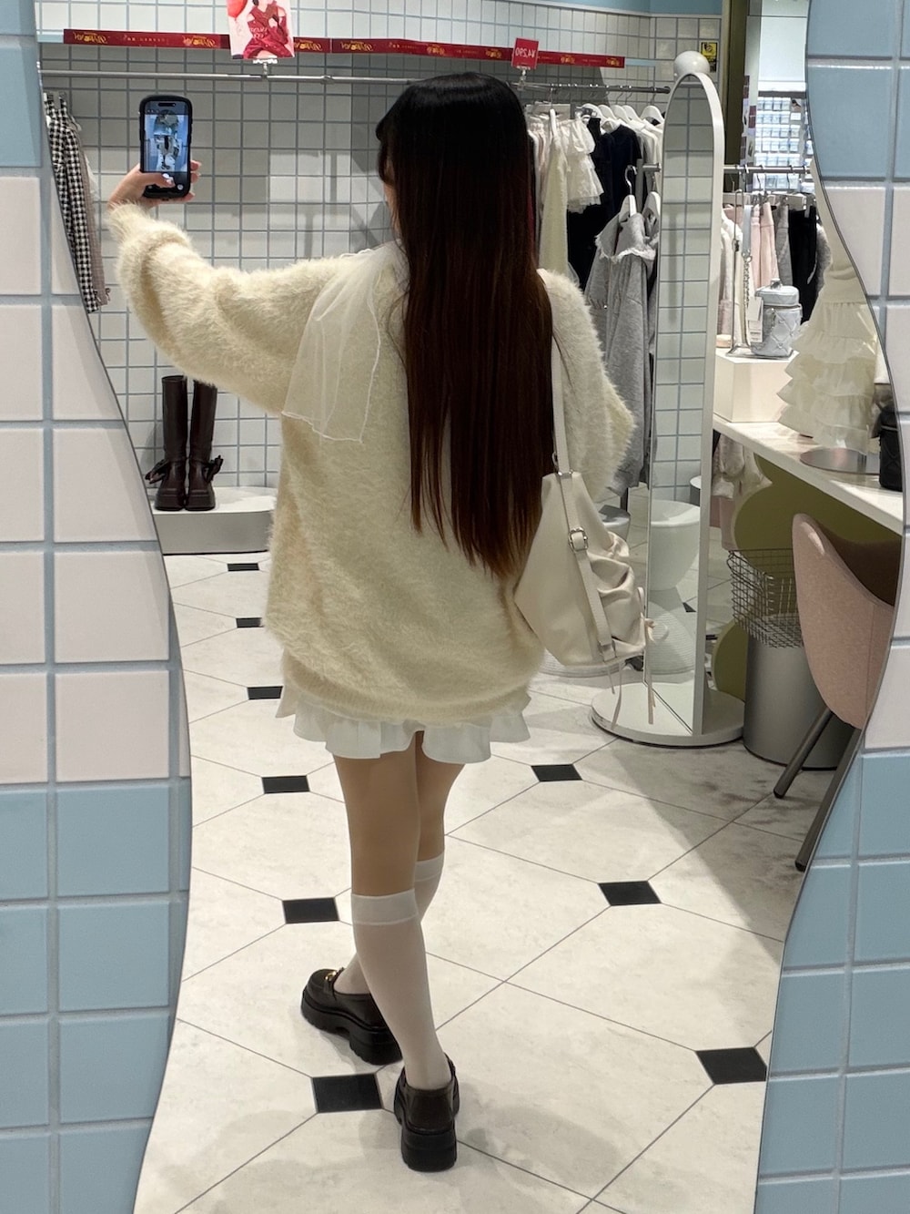 イエロー系のワンピース、ホワイト系のスカート、ホワイト系のショルダーバッグを着用したレディースの冬コーディネートの3枚目の写真