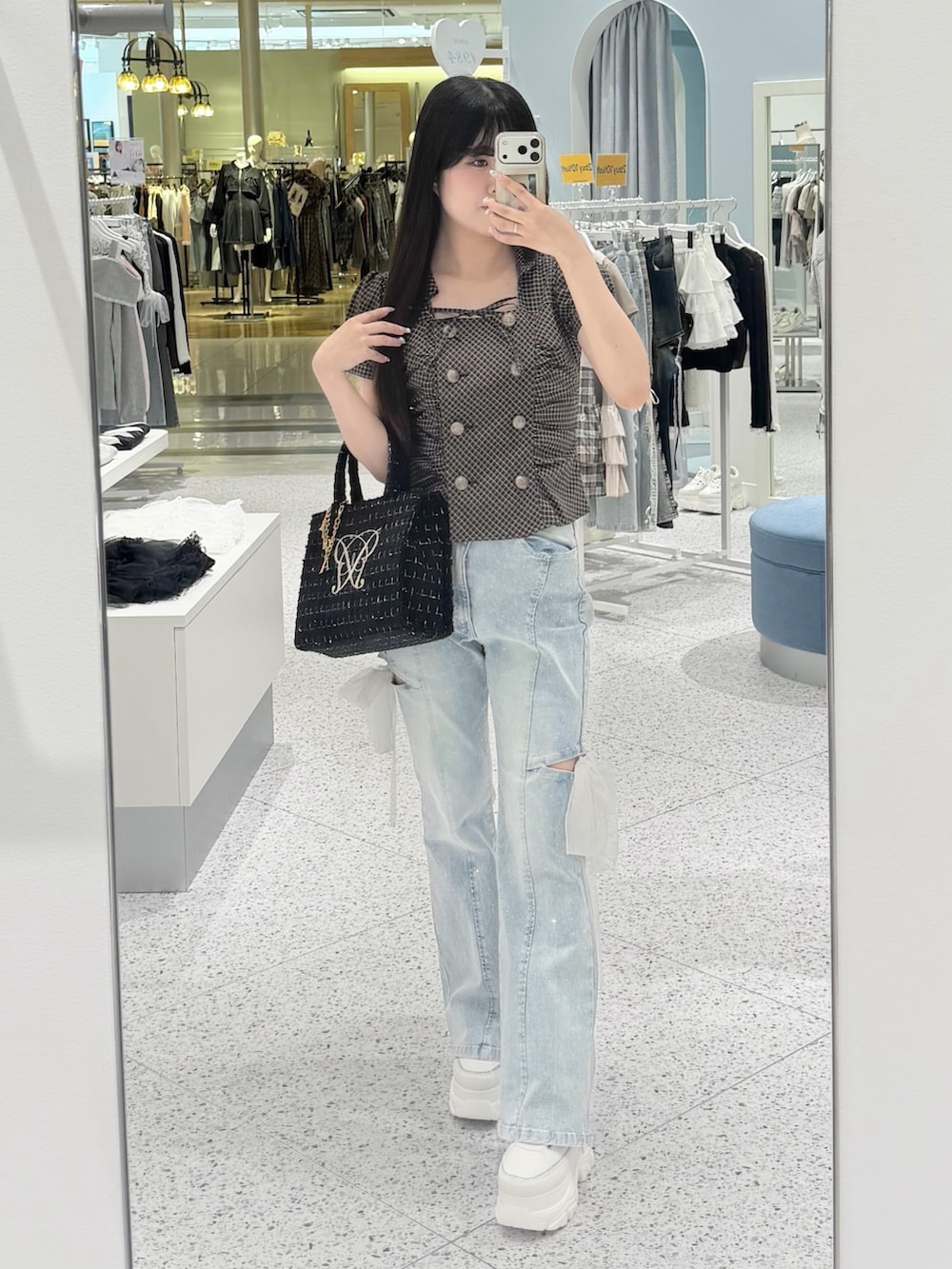 ブラウン系のシャツ/ブラウス、ブルー系のデニムパンツ、ブラック系のトートバッグを着用したレディースの秋コーディネートの5枚目の写真