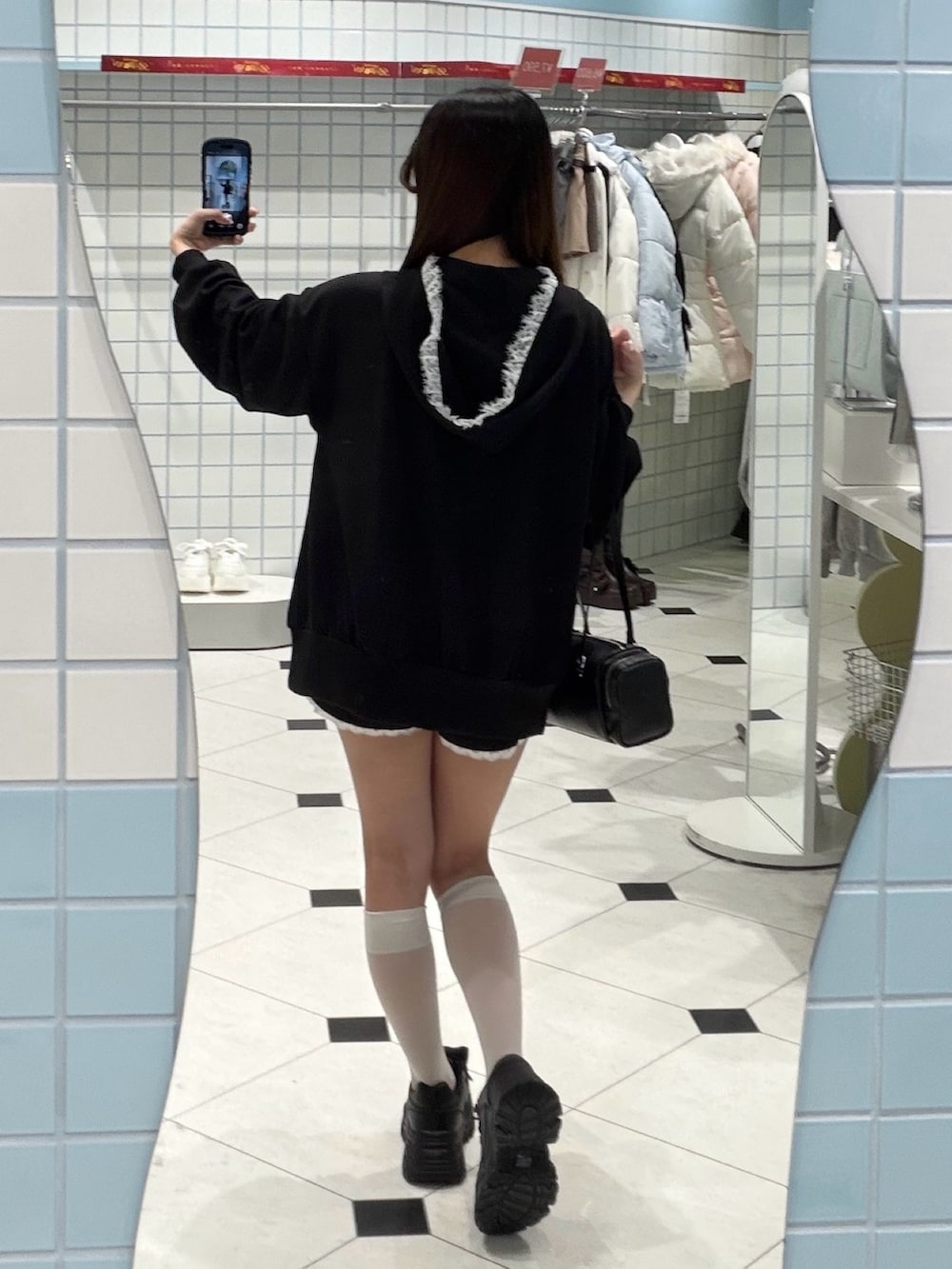 ブラック系のパーカー、ブラック系のその他パンツ、ブラック系のトートバッグを着用したレディースの冬コーディネートの4枚目の写真