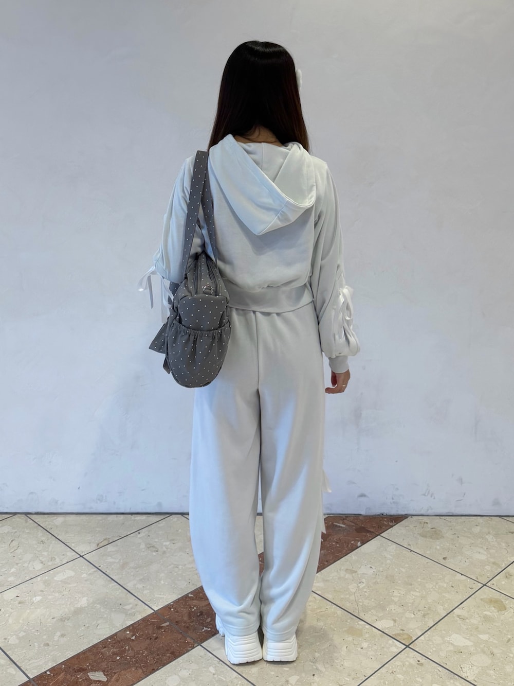 グリーン系のパーカー、グリーン系のスウェットパンツ、グレー系のボストンバッグを着用したレディースの冬コーディネートの4枚目の写真