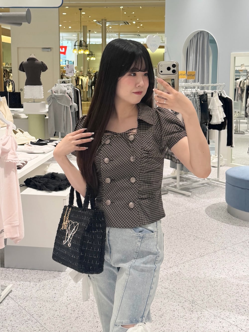 ブラウン系のシャツ/ブラウス、ブルー系のデニムパンツ、ブラック系のトートバッグを着用したレディースの秋コーディネートの3枚目の写真
