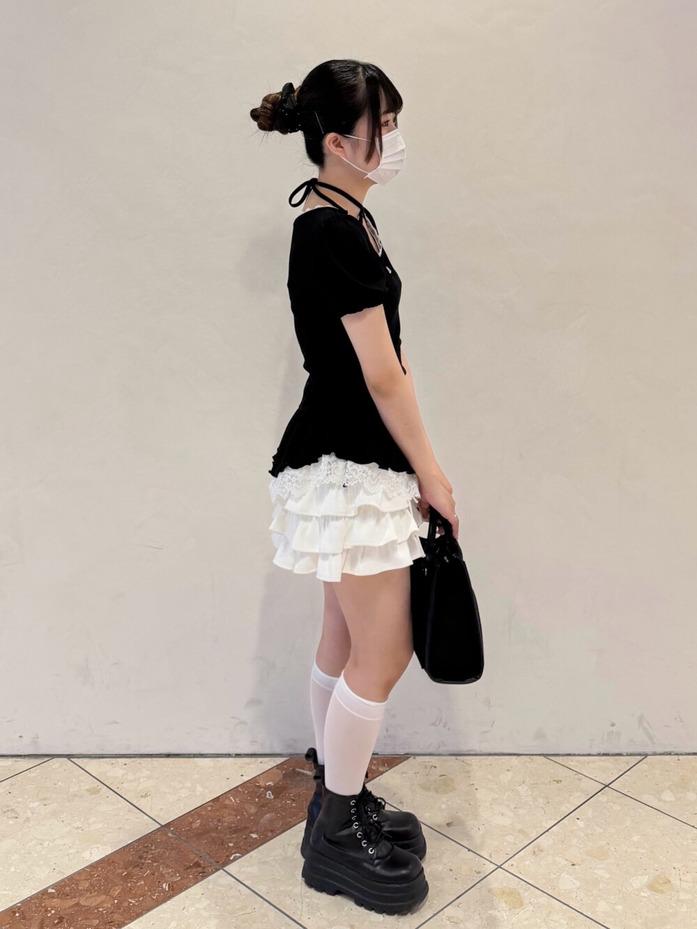 ブラック系のTシャツ/カットソー、ホワイト系のスカート、ブラック系のトートバッグを着用したレディースの春コーディネートの2枚目の写真
