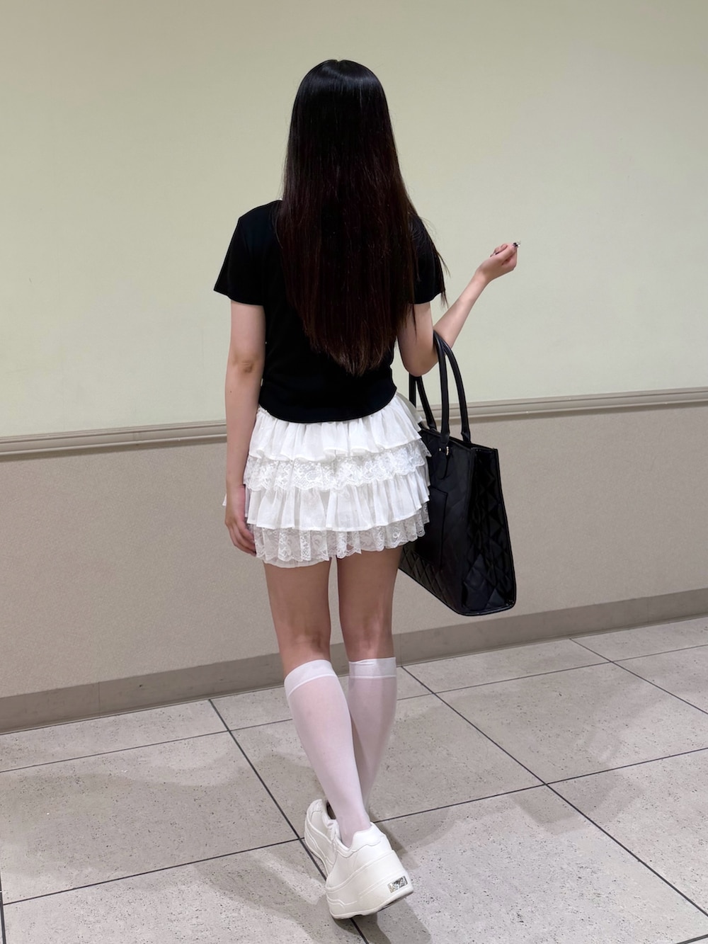 ブラック系のTシャツ/カットソー、ホワイト系のスカート、ブラック系のトートバッグを着用したレディースの夏コーディネートの3枚目の写真