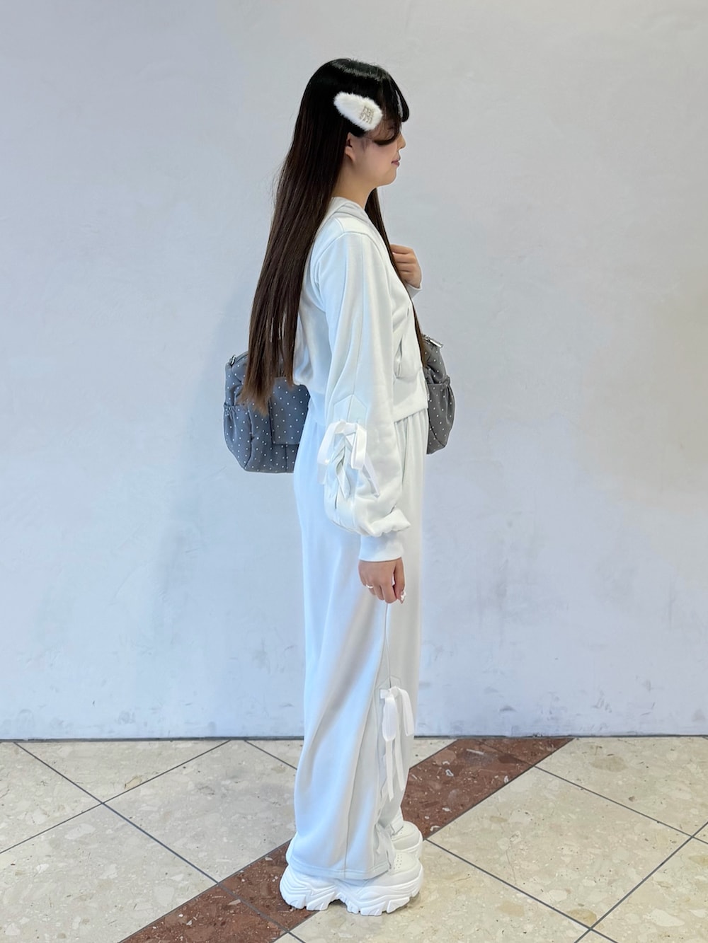 グリーン系のパーカー、グリーン系のスウェットパンツ、グレー系のボストンバッグを着用したレディースの冬コーディネートの3枚目の写真