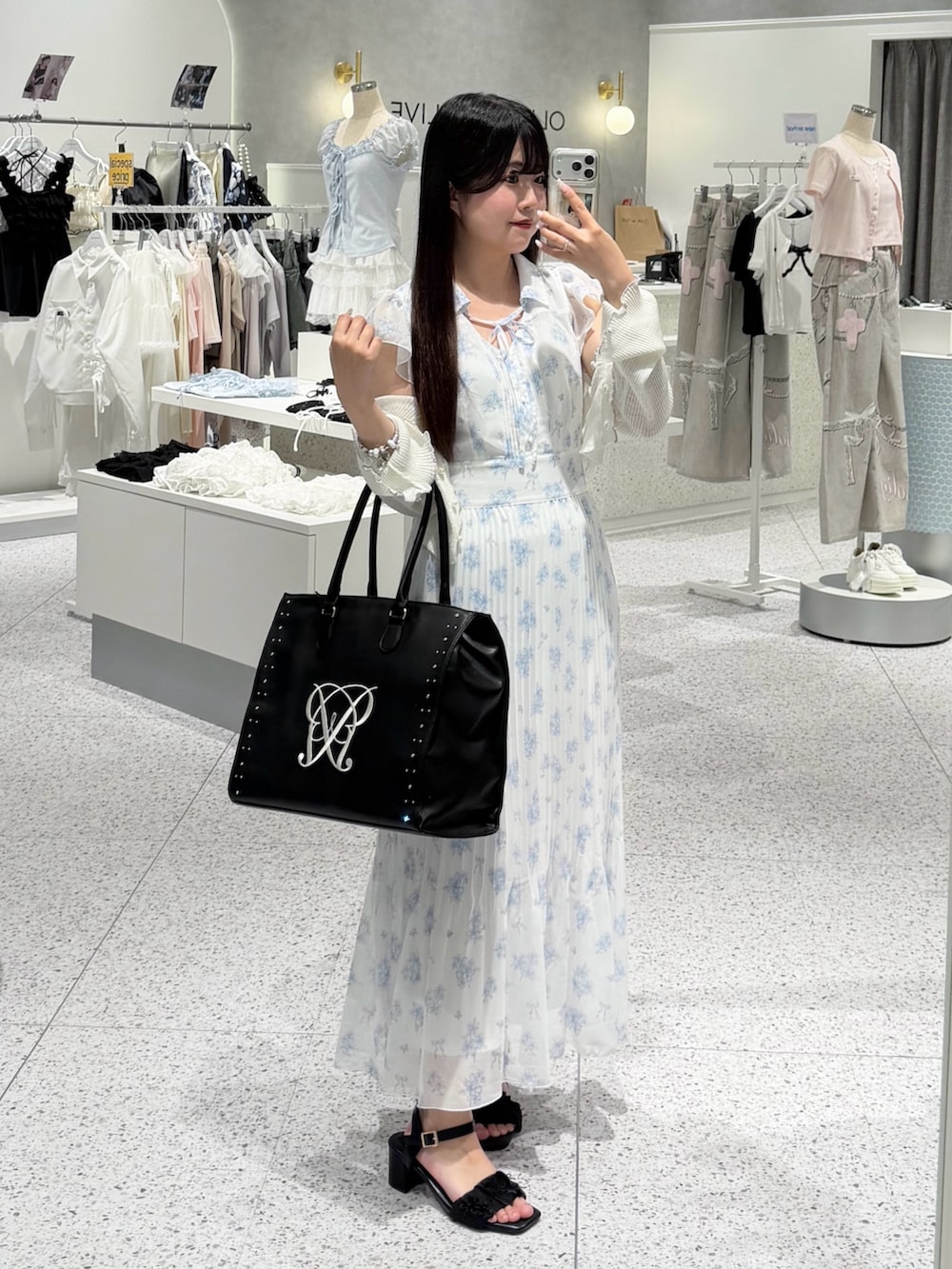 ブルー系のワンピース、ホワイト系のカーディガン/ボレロ、ブラック系のサンダルを着用したレディースの夏コーディネートの4枚目の写真