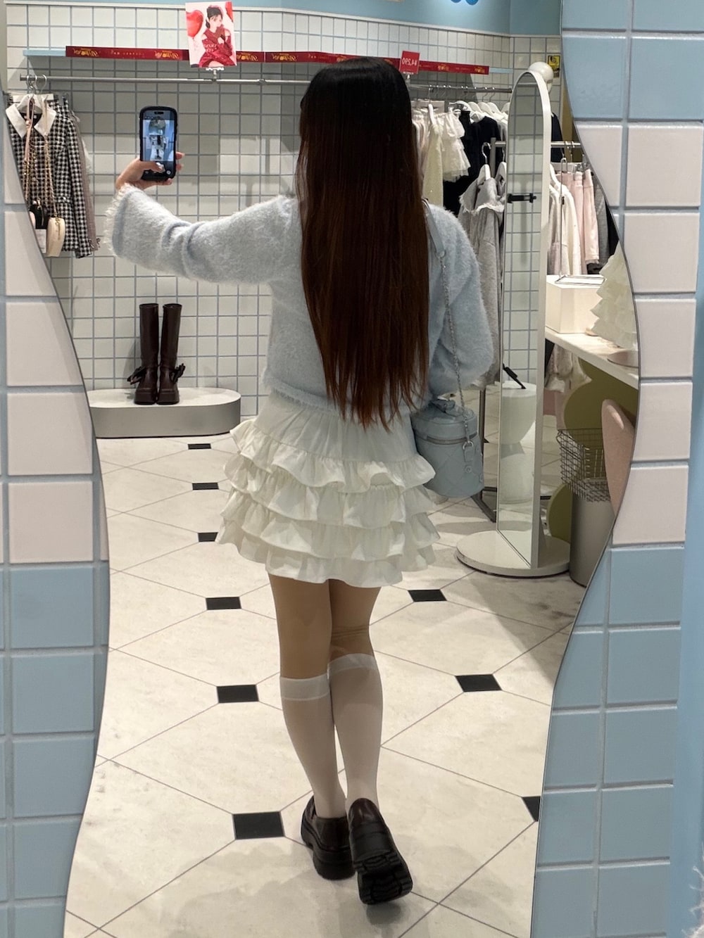 ブルー系のキャミソール、ブルー系のカーディガン/ボレロ、ホワイト系のスカートを着用したレディースの冬コーディネートの3枚目の写真