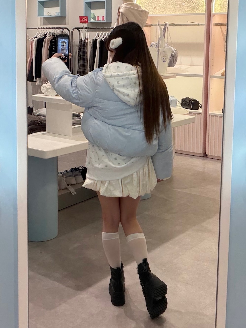 ブルー系のダウンジャケット/コート、ホワイト系のパーカー、ホワイト系のスカートを着用したレディースの冬コーディネートの4枚目の写真