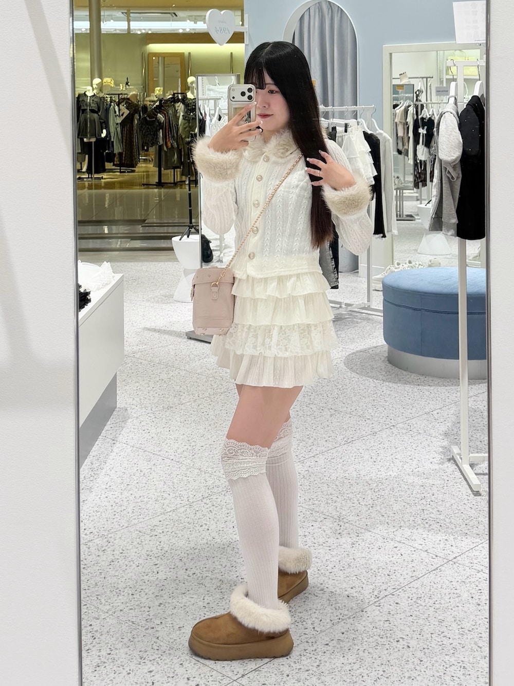 ホワイト系のパーカー、ホワイト系のスカート、ピンク系のショルダーバッグを着用したレディースの秋コーディネートの5枚目の写真