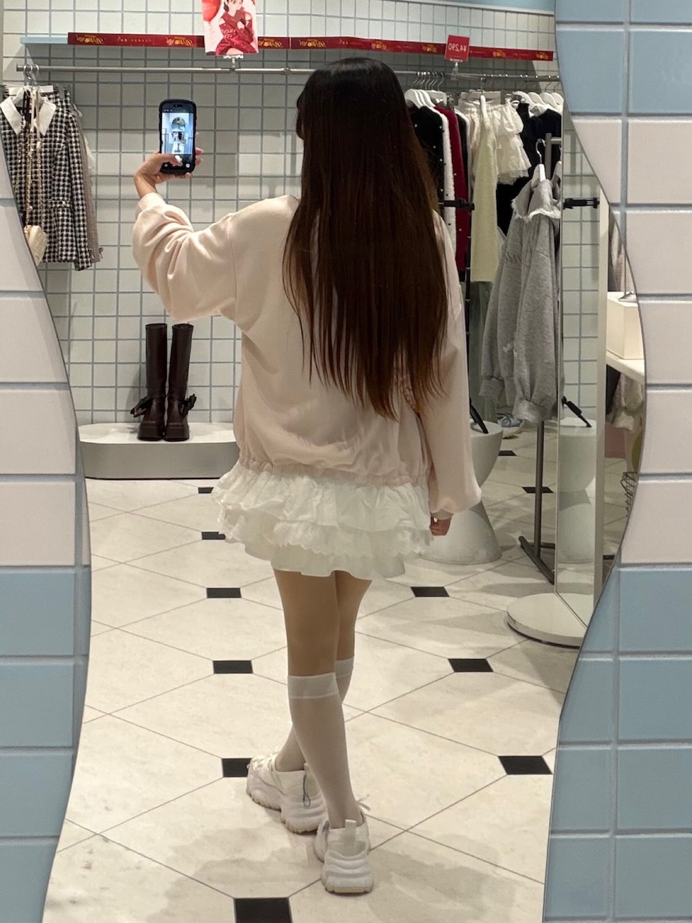 ピンク系のスウェット、ピンク系のショルダーバッグ、ホワイト系のスニーカーを着用したレディースの冬コーディネートの3枚目の写真