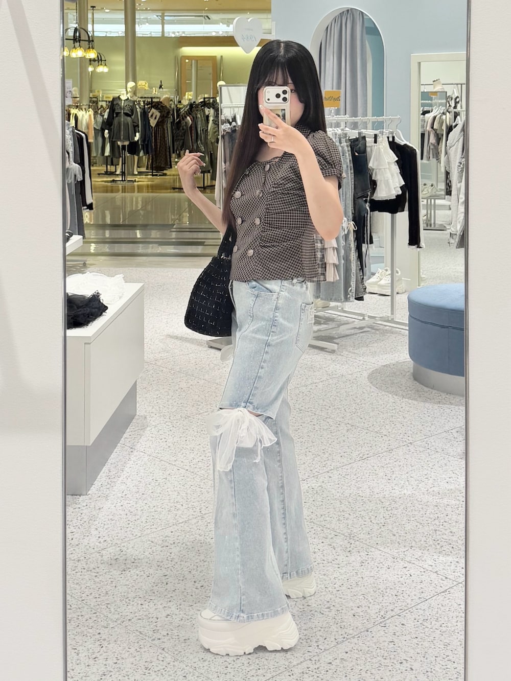 ブラウン系のシャツ/ブラウス、ブルー系のデニムパンツ、ブラック系のトートバッグを着用したレディースの秋コーディネートの2枚目の写真
