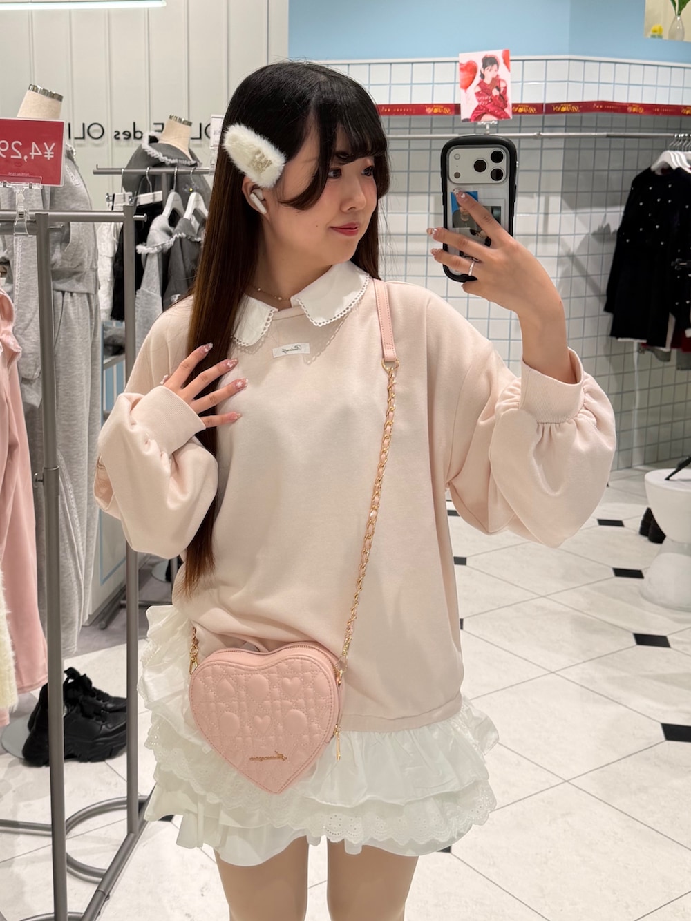 ピンク系のスウェット、ピンク系のショルダーバッグ、ホワイト系のスニーカーを着用したレディースの冬コーディネートの2枚目の写真