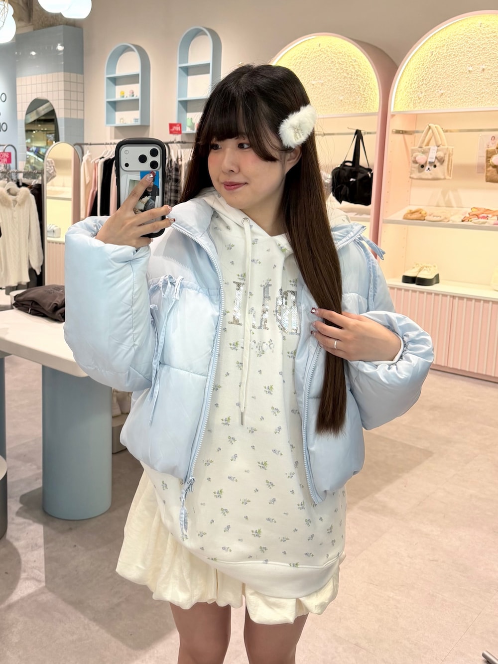 ブルー系のダウンジャケット/コート、ホワイト系のパーカー、ホワイト系のスカートを着用したレディースの冬コーディネートの3枚目の写真