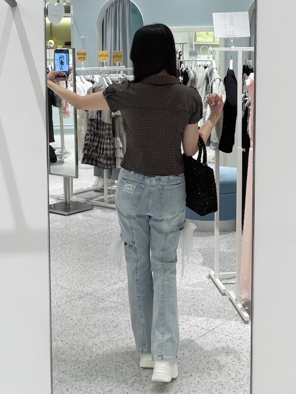 ブラウン系のシャツ/ブラウス、ブルー系のデニムパンツ、ブラック系のトートバッグを着用したレディースの秋コーディネートの4枚目の写真