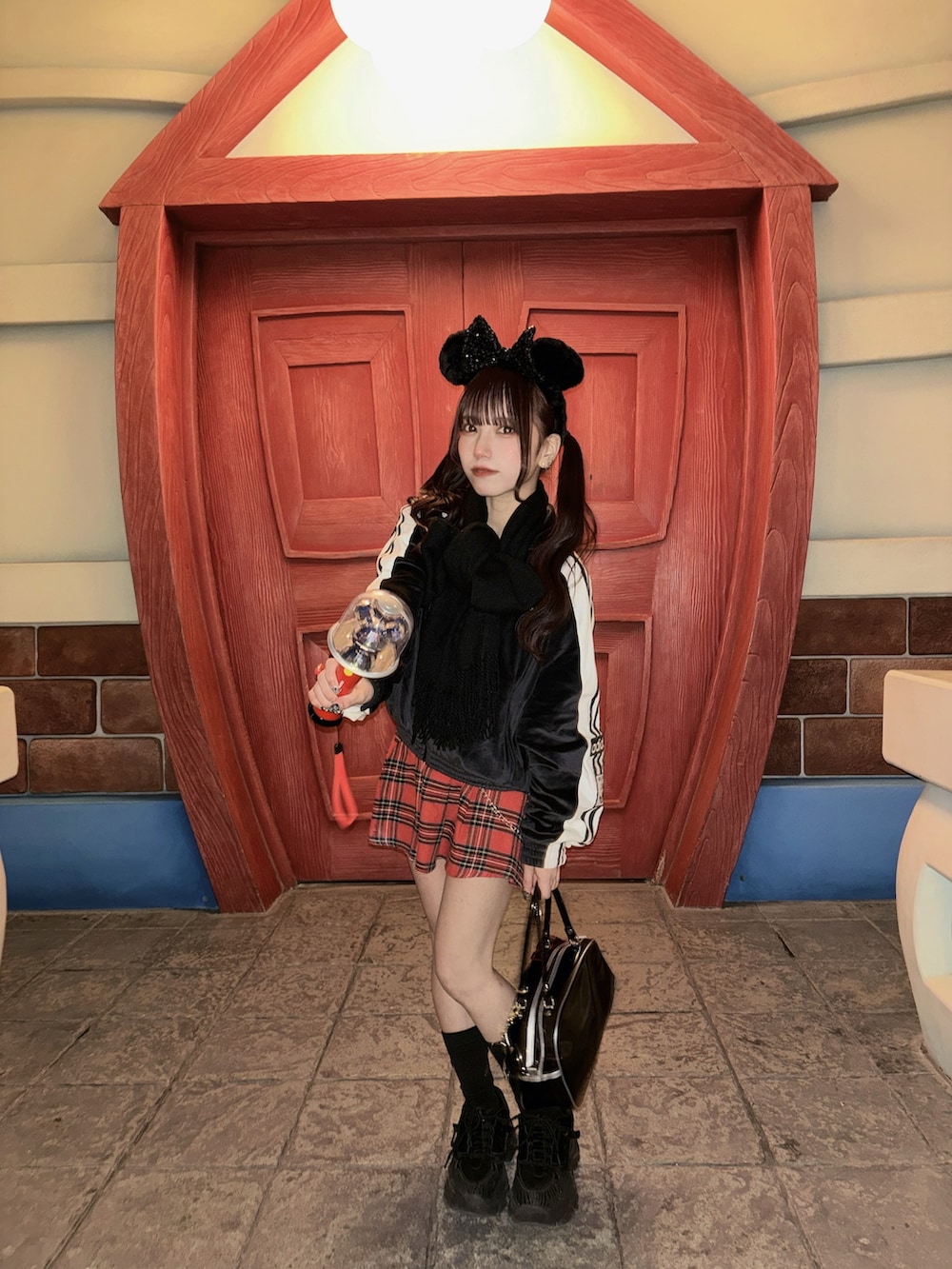 ブラック系のジャージ、レッド系のスカートを着用したレディースの春コーディネートの2枚目の写真