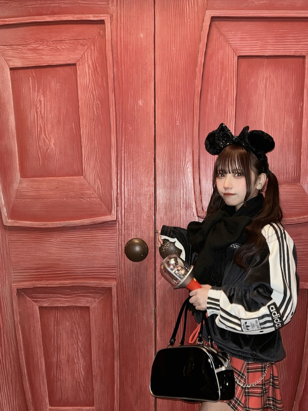 ブラック系のジャージ、レッド系のスカートを着用したレディースの春コーディネートの3枚目の写真