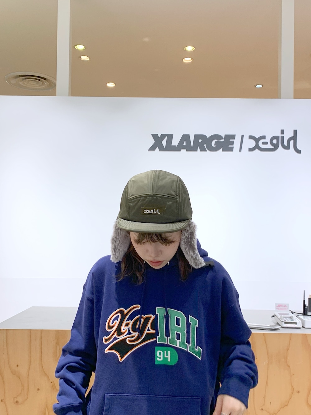 ブルー系のパーカー、その他のスウェットパンツ、グリーン系のキャップを着用したレディースの秋コーディネートの3枚目の写真