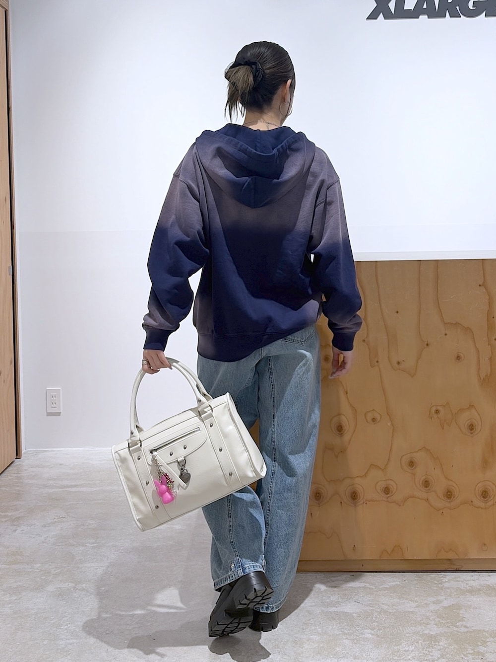 ブルー系のデニムパンツ、ホワイト系のショルダーバッグ、ブルー系のパーカーを着用したレディースの冬コーディネートの2枚目の写真