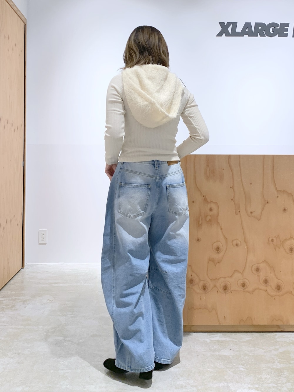 ホワイト系のパーカー、ブルー系のデニムパンツ、ブラック系のショルダーバッグを着用したレディースの冬コーディネートの2枚目の写真