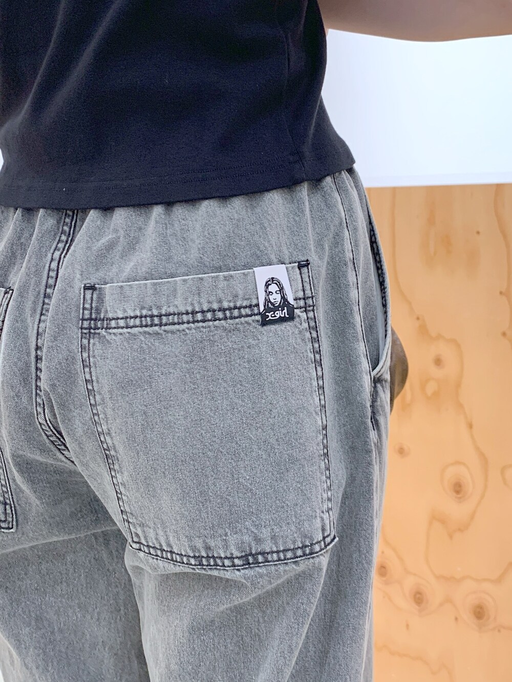 ブラック系のデニムパンツ、ゴールド系のハンドバッグ、ブラック系のTシャツ/カットソーを着用したレディースの夏コーディネートの4枚目の写真