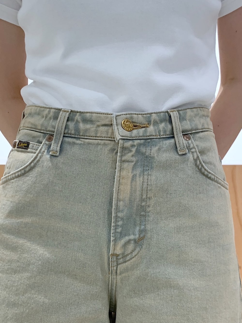 ブルー系のデニムパンツ、ホワイト系のハンドバッグ、ホワイト系のTシャツ/カットソーを着用したレディースの夏コーディネートの4枚目の写真