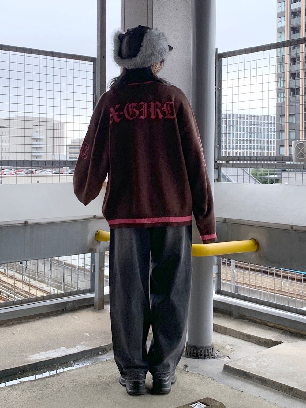 ブラウン系のニット/セーター、ブラック系のデニムパンツ、ブラック系のキャップを着用したレディースの秋コーディネートの2枚目の写真