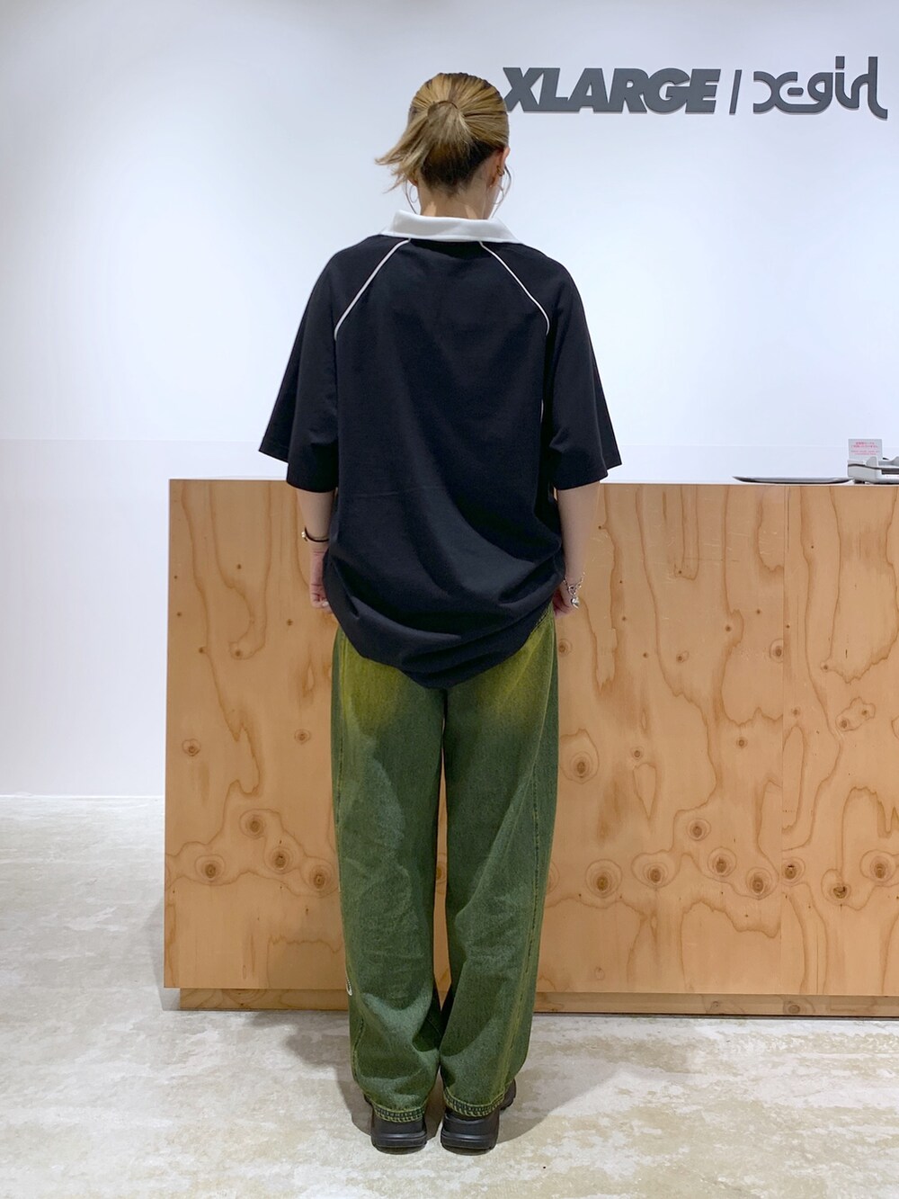 ブルー系のデニムパンツ、ブラック系のワンピース、シルバー系のネックレスを着用したレディースの夏コーディネートの3枚目の写真