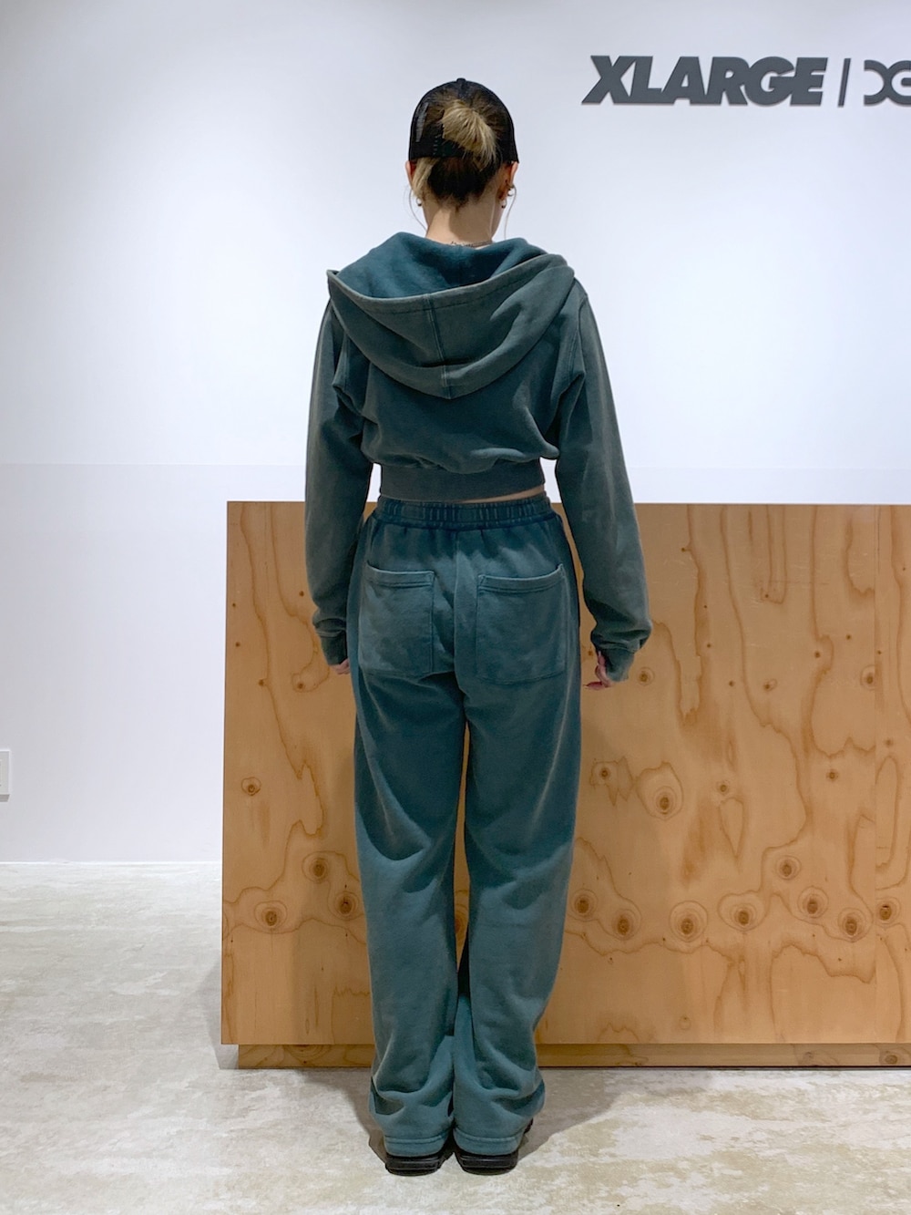 グリーン系のスウェットパンツ、グリーン系のパーカー、ブラック系のキャップを着用したレディースの夏コーディネートの3枚目の写真